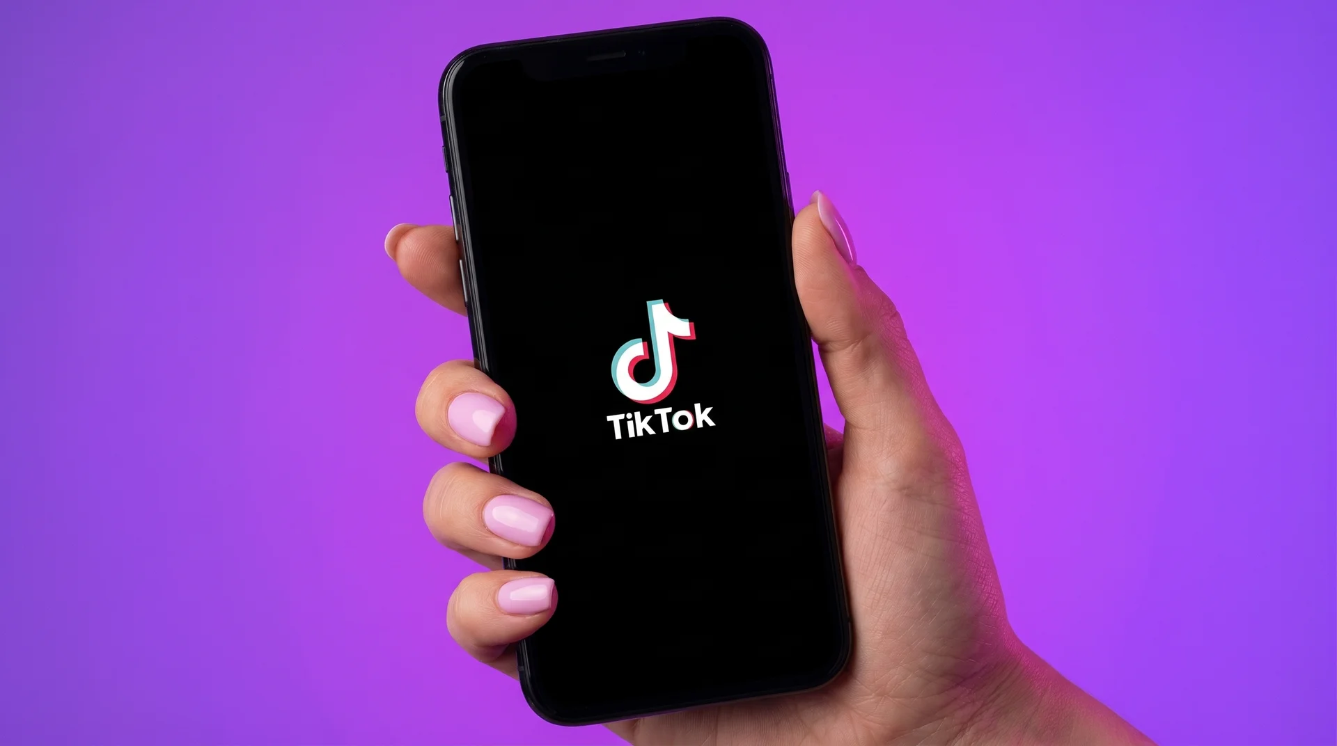 Close-up of a hand endlessly scrolling through short videos on a phone screen in a dark room